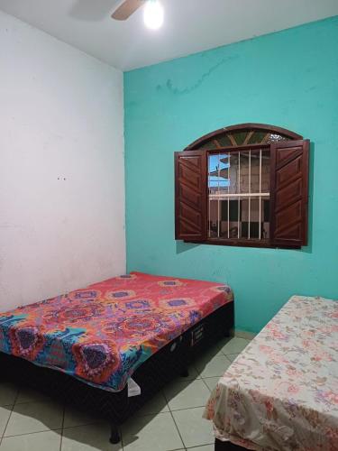 um quarto com 2 camas e uma janela em Casa Itaúnas em Itaúnas