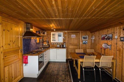 cocina con paredes de madera y techo de madera en Skipperhuset, en Sørvær
