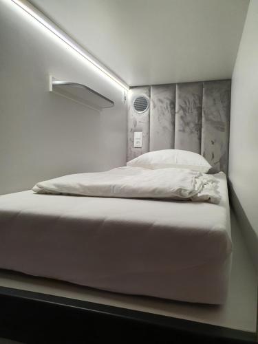 a bedroom with a white bed with a headboard at Dutchies Hostel in Amsterdam