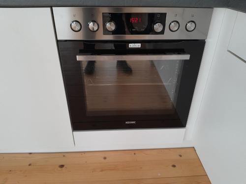 a microwave oven in a kitchen with a wooden floor at MäuseScheune in Sankt Annen