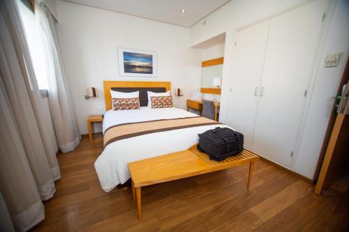 a bedroom with a bed and a suitcase on a table at Le Pietri Urban Hotel in Rabat