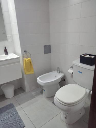 a white bathroom with a toilet and a sink at Comodo Depto Zona Plaza Paso con opcion de cochera by Lofter in La Plata