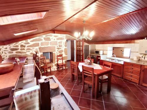 a kitchen with a table and a stone fireplace at 3 bedrooms villa with private pool furnished garden and wifi at Segoes 