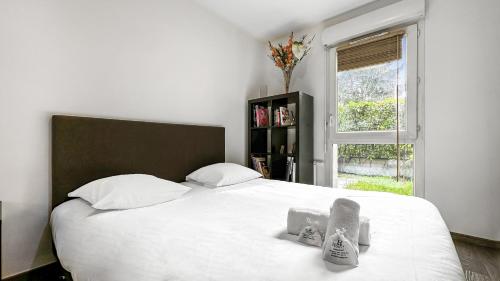 een slaapkamer met een groot wit bed en een raam bij Homey Melody - Proche Centre, Parking, Wifi, Terrace in Annemasse