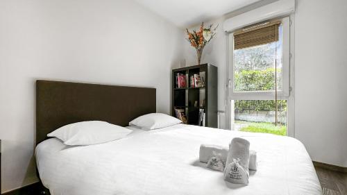 une chambre avec un grand lit blanc et une fenêtre dans l'établissement Homey Melody - Proche Centre, Parking, Wifi, Terrace, à Annemasse