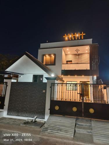 a large white house with a balcony at night at Sai Home Stay in Tiruvannāmalai