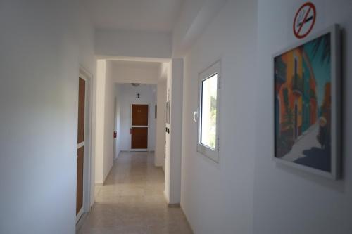 a hallway with white walls and paintings on the wall at Stef & Stam Nerantzis in Himare
