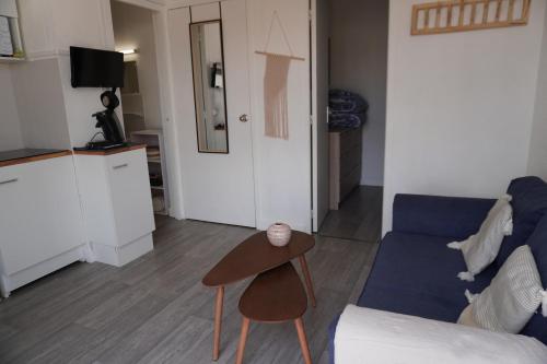 un salon avec un canapé bleu et une table dans l'établissement Studio - Grande Plage -Terrasse, au Barcarès