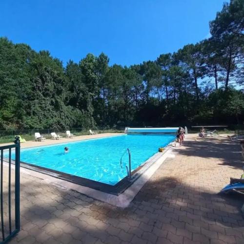 une grande piscine bleue avec des gens dedans dans l'établissement Maison familiale - Marina de Talaris - Lac Lacanau, à Lacanau