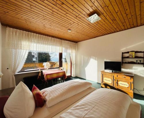 a bedroom with a large bed and a desk at Gästehaus Herzog am Bodensee in Uhldingen-Mühlhofen