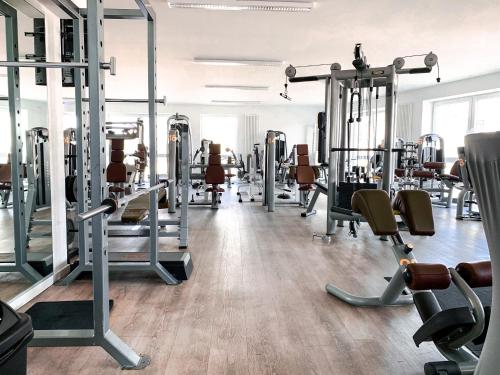 a gym with lots of treadmills and machines at nordica Hotel Friesenhof in Büsum