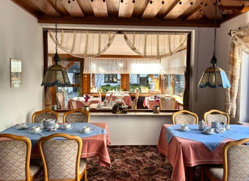 a restaurant with two tables and chairs and a mirror at Gästehaus Herzog in Uhldingen-Mühlhofen