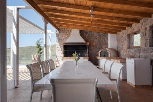 a dining room with a table and chairs and a fireplace at Aphea Retreat Villa in Aegina Town