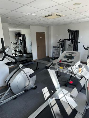 a room with a gym with a treadmill and machines at La Bonbonniere - Sure Hotel Collection by Best Western in Talant