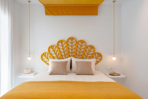 a bedroom with a large bed with a yellow headboard at Croco Mykonos in Tourlos