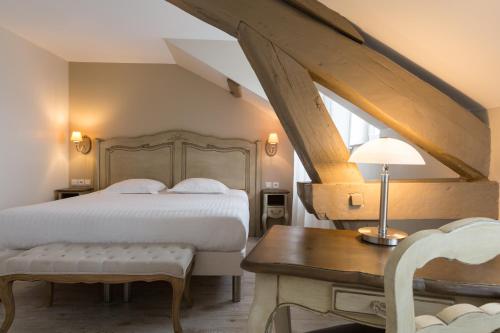 1 dormitorio con cama, mesa y escritorio en The Originals Boutique, Hôtel Les Poèmes de Chartres (Inter-Hotel), en Chartres