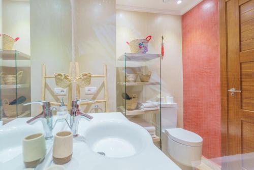 uma casa de banho com um lavatório branco e um WC. em Résidence piscine avec terrasse privé em Marrakech