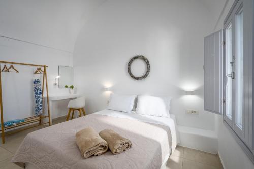 biała sypialnia z łóżkiem z 2 ręcznikami w obiekcie Spectacular view Caldera St V w mieście Megalochori