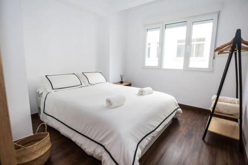 1 dormitorio con 1 cama blanca grande y 2 almohadas en Joya en el corazón de Ribeira, en Ribeira