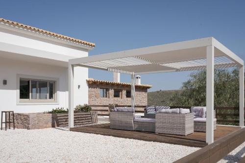 a pergola with two couches on a wooden deck at Aphea Retreat Villa in Aegina Town