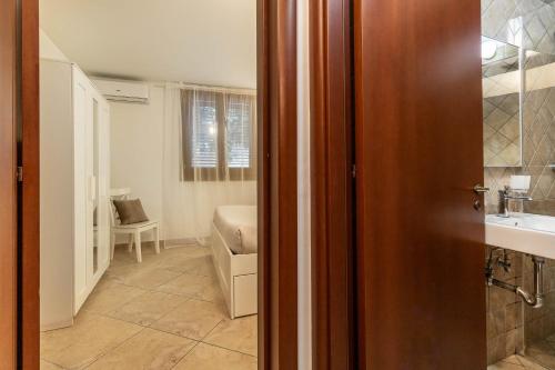 a door to a bathroom with a sink and a room at Il Giardino dei Mesagnesi - Lecce Selection in Lecce