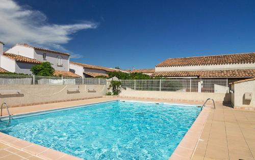 une grande piscine devant une maison dans l'établissement SAMARIA VILLAGE Joli appartement 5 personnes piscine à Rochelongue Cap d'Agde, au Cap d'Agde