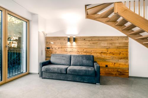 a blue couch in a room with a wooden wall at Untermoarhof Albeins in Bressanone