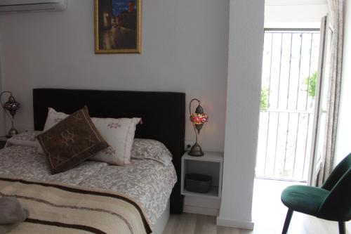 1 dormitorio con 1 cama, 1 silla y 1 ventana en Apartamentos Vado - Cuesta de Alhacaba en Granada