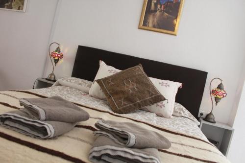 a bed with towels and pillows on top of it at Apartamentos Vado - Cuesta de Alhacaba in Granada