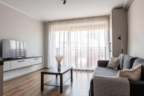a living room with a couch and a table at CLUJSTAYS Urban Nest Central Apartment in Cluj-Napoca