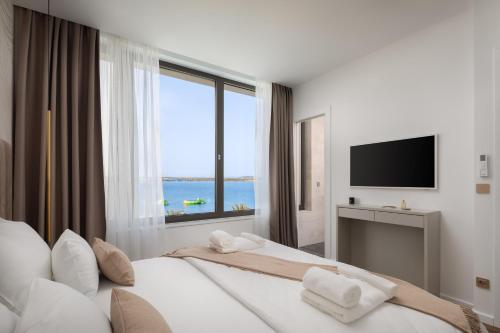 sypialnia z 2 łóżkami i dużym oknem w obiekcie The Palms resort w mieście Tkon