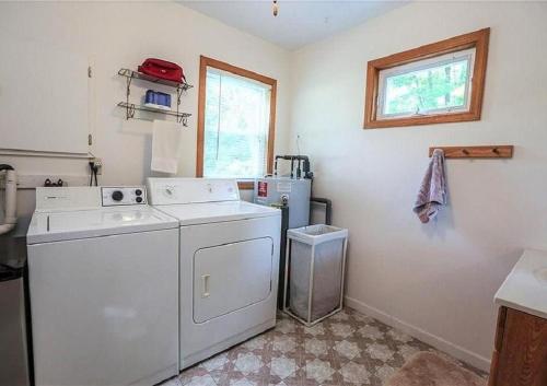 una cocina con lavadora y secadora y una ventana en Cottage on Lake Ontario en Waterport