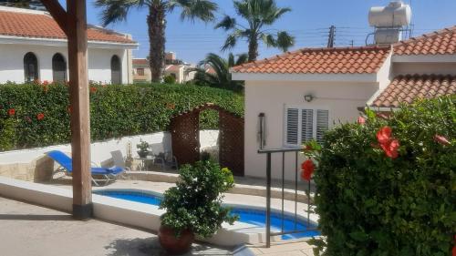 una casa con piscina en un patio en Villa Best Holiday- breathtaking sea views, amazing garden, private pool, BBQ, next to CORAL BAY, Lower Peyia, Paphos, en Peyia