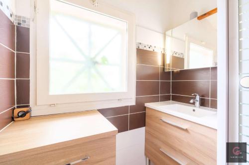 uma casa de banho com um lavatório e uma janela em Biscarrosse Lac Joli duplex 4 ou 6 personnes à 200 m du LAC em Biscarrosse