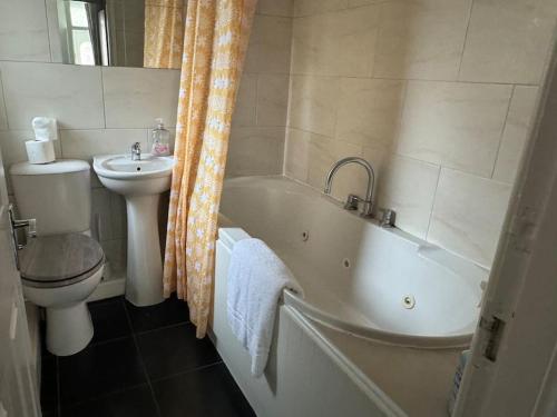 a bathroom with a toilet and a tub and a sink at Liverpool townhouse sleeps 6 with free on street parking in Liverpool