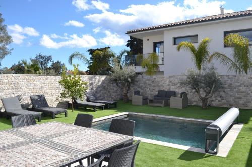 une cour avec une table et des chaises ainsi qu'une piscine dans l'établissement ETOILE DU BERGER Saint Aygulf 3 Villas et 4 appartements jardin individuel et piscine chauffée en saison - la mer et les plages 450 m, à Saint-Aygulf