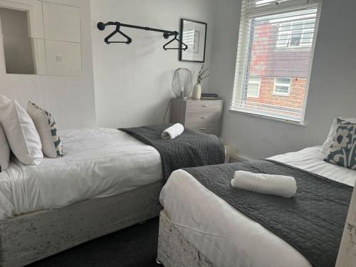 a bedroom with two beds and a window at Liverpool townhouse sleeps 6 with free on street parking in Liverpool