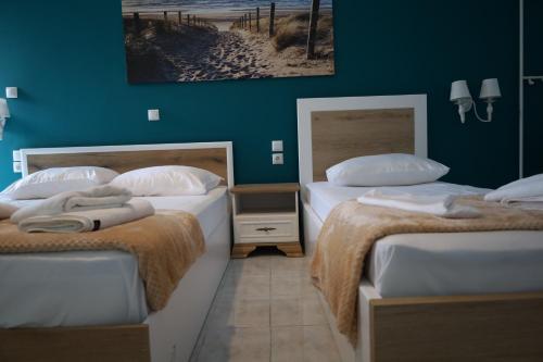 two beds in a room with green walls at Stef & Stam Nerantzis in Himare