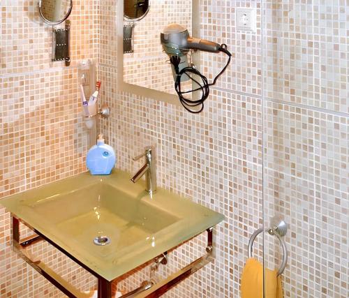 a bathroom with a sink with a camera on the wall at One bedroom apartement with furnished terrace and wifi at Tolva in Tolva