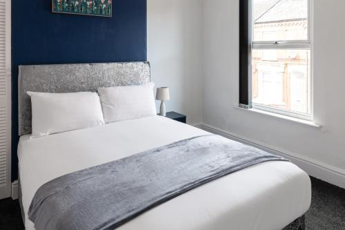 een slaapkamer met een wit bed en een raam bij Host & Stay - Anfield Hideaway in Liverpool
