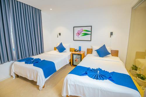 two beds in a room with blue and white at The B Resort in Kampot