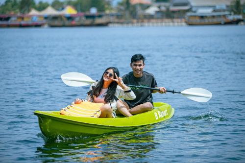 a man and a woman in a kayak on the water at The B Resort in Kampot