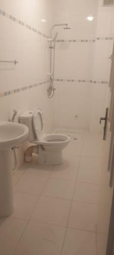 a white bathroom with a toilet and a sink at Villa a saidia in Saïdia