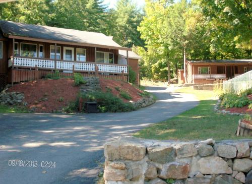 a house with a stone wall next to a driveway at Boulders Resort in Lake George