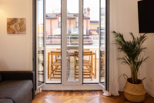 Gaffurio Apartments في ميلانو: غرفة معيشة مع شرفة مع طاولة