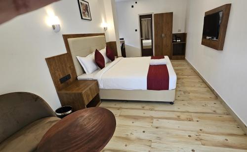 ein Schlafzimmer mit einem Bett und einem Sofa in einem Zimmer in der Unterkunft INDIANA HILLS in Shillong