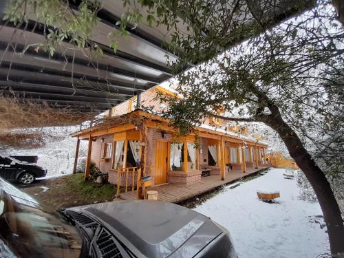 ein kleines Holzhaus mit Schnee auf dem Boden in der Unterkunft Santos Lugares Cabañas in Junín de los Andes