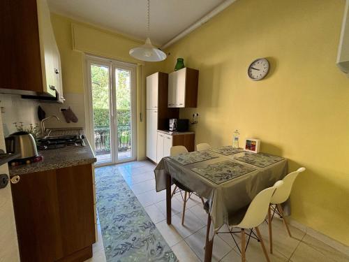 a kitchen with a table and a clock on the wall at New apartment next to the sea in Bordighera