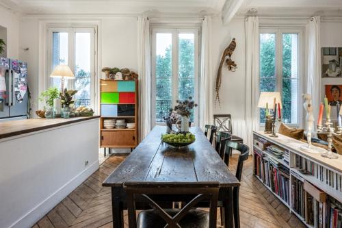 - une cuisine avec une table, des chaises et des fenêtres dans l'établissement Appart typique Montmartre, à Paris