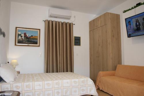 a hotel room with a bed and a couch at KOLLITAKI in Selínia